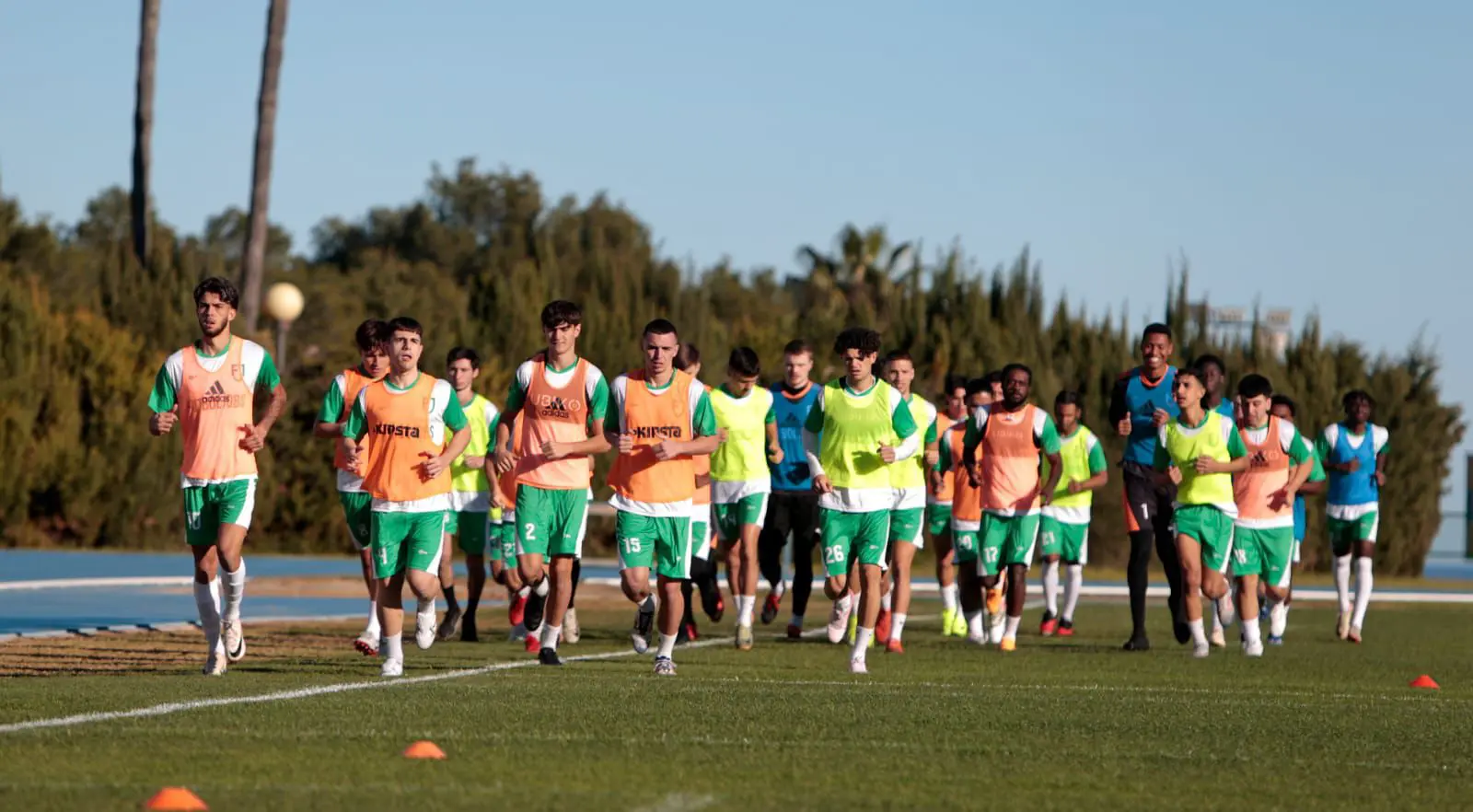 A group of soccer players sprinting across the field during a match, showcasing teamwork spirit during a game.