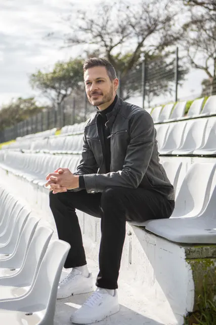 Man sitting in the stands of a soccer stadium, outside