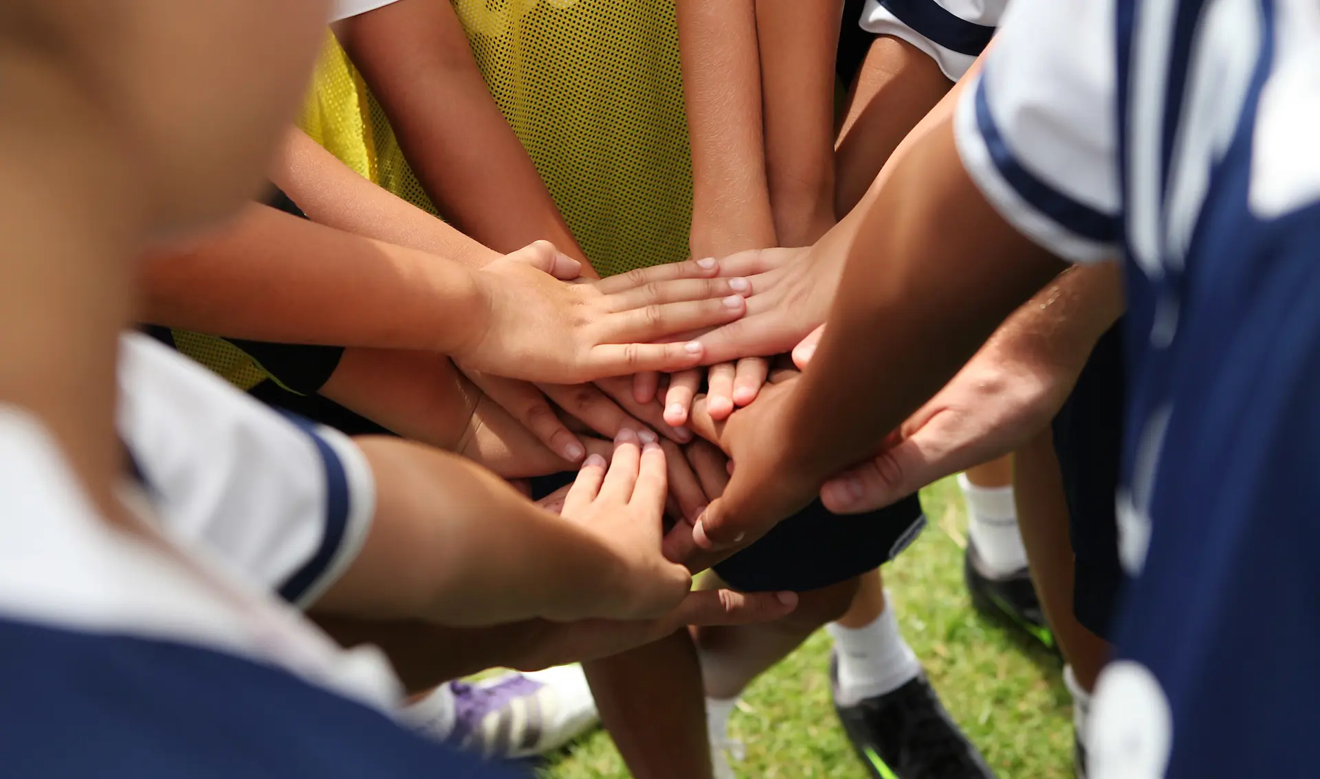 Young soccer players with their hands together in a huddle