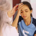 Image of yong female soccer player getting head checked for concussion. CTE concussions protocol