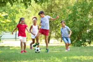 kids playing soccer on the grass, unstructured