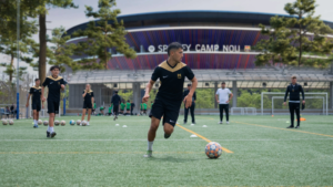 Player in fron tof the Camp Nou, Barcelona SPain. Soccer Development at TNL Academy.