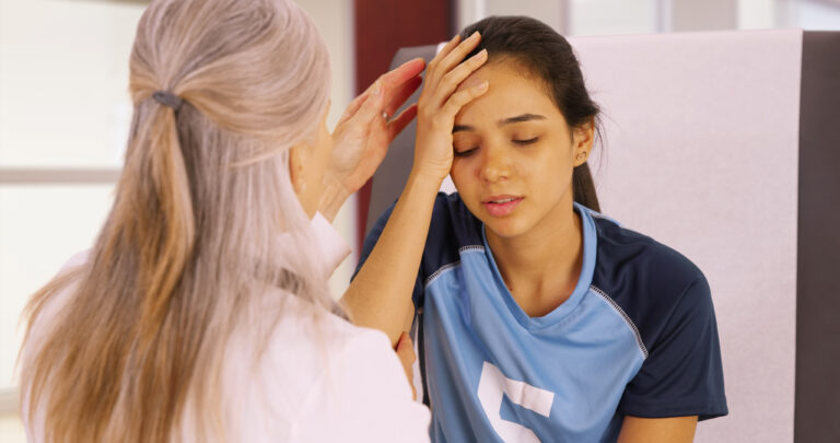 Image of yong female soccer player getting head checked for concussion. CTE concussions protocol