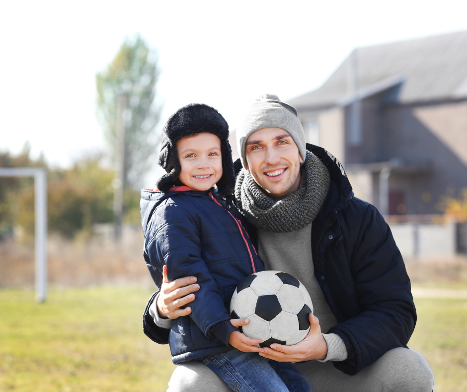 Father and son outside with a soccer ball