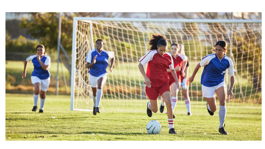 Girls soccer players running during a youth game on National Girls & Women in Sports Day