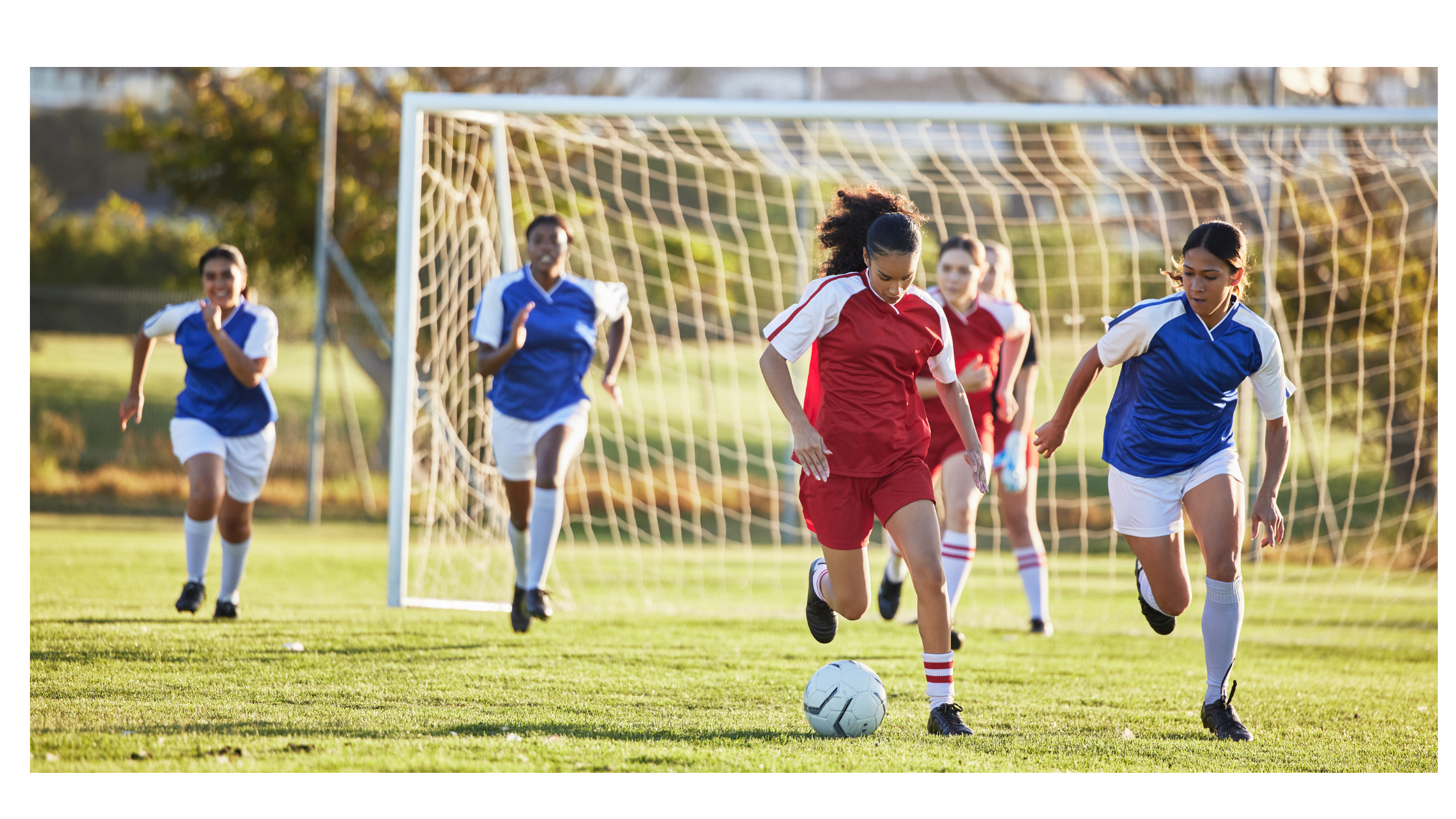 Girls soccer players running during a youth game on National Girls & Women in Sports Day