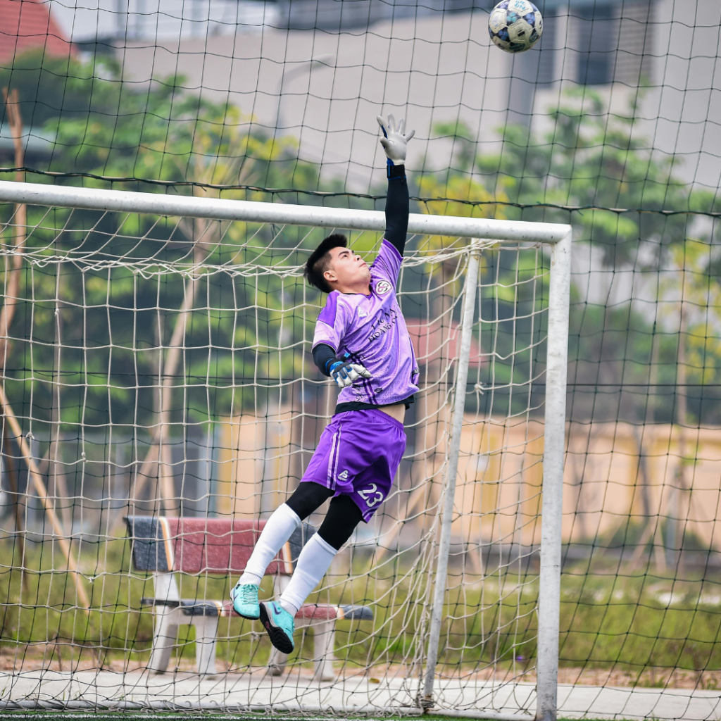 Youth Soccer Goalkeeper jumping up to stop a goal
